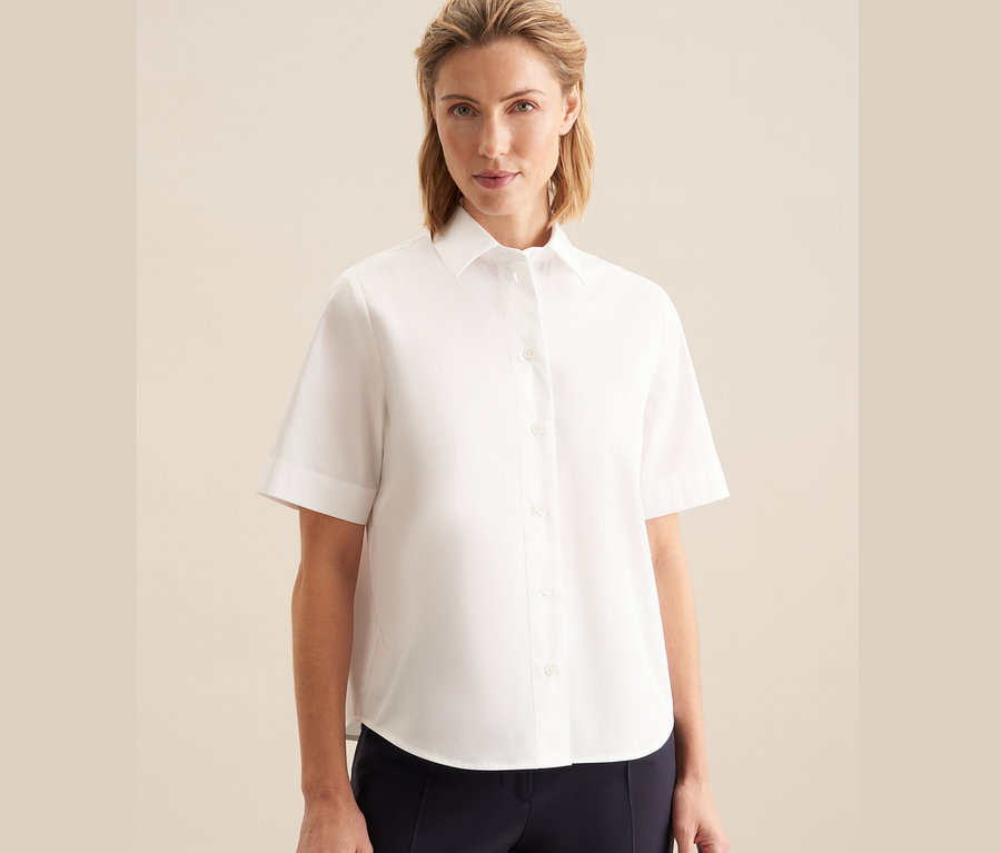Frau trägt eine weiße Seidensticker Kurzarm-Bluse.