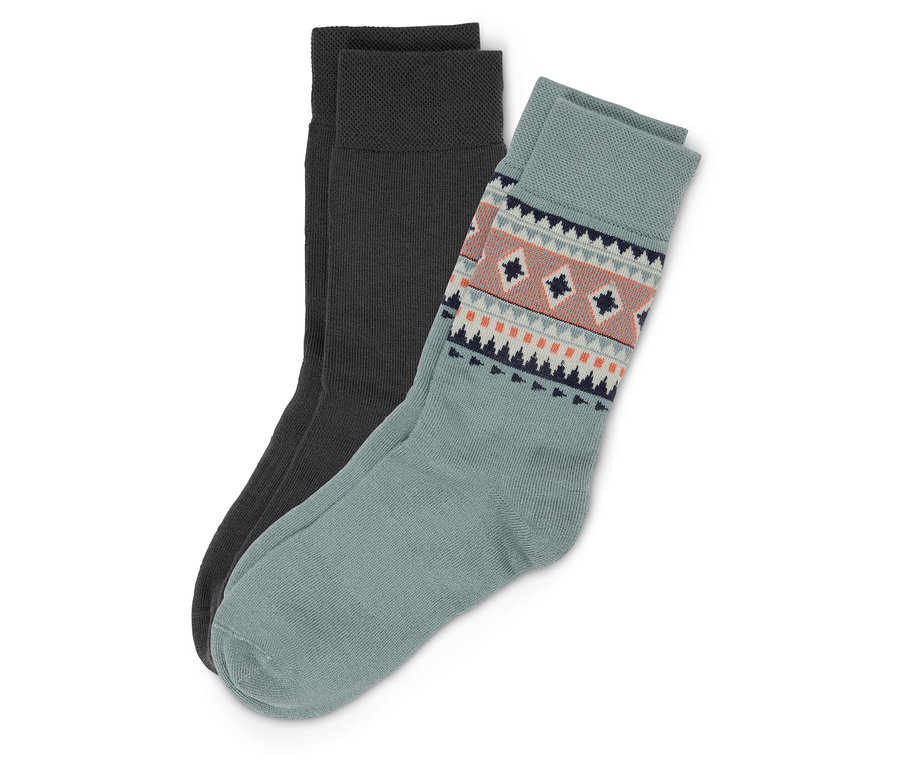 Zwei Socken: ein Paar dunkelgrau, ein Paar blaugrün mit geometrischem Muster am Bund.