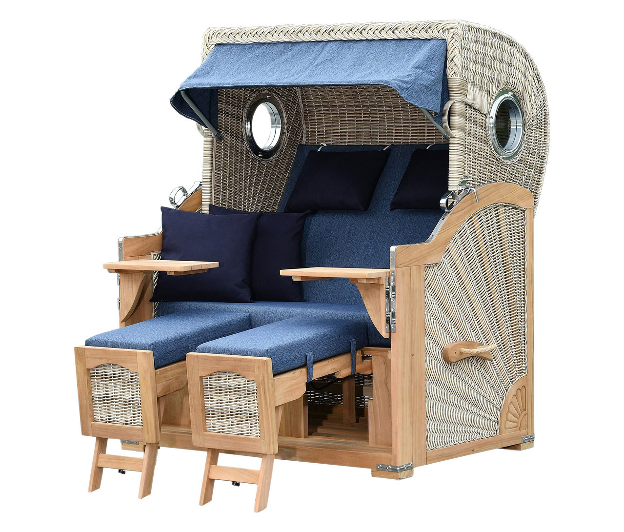 Ein Strandkorb aus Korbgeflecht mit blauem Bezug, zwei herausziehbaren Fußstützen und kleinen Tischen an den Seiten.
