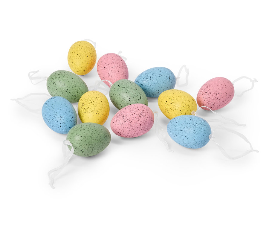 Ein Dutzend pastellfarbene Ostereier mit weißen Bändern liegen auf einem weißen Hintergrund.