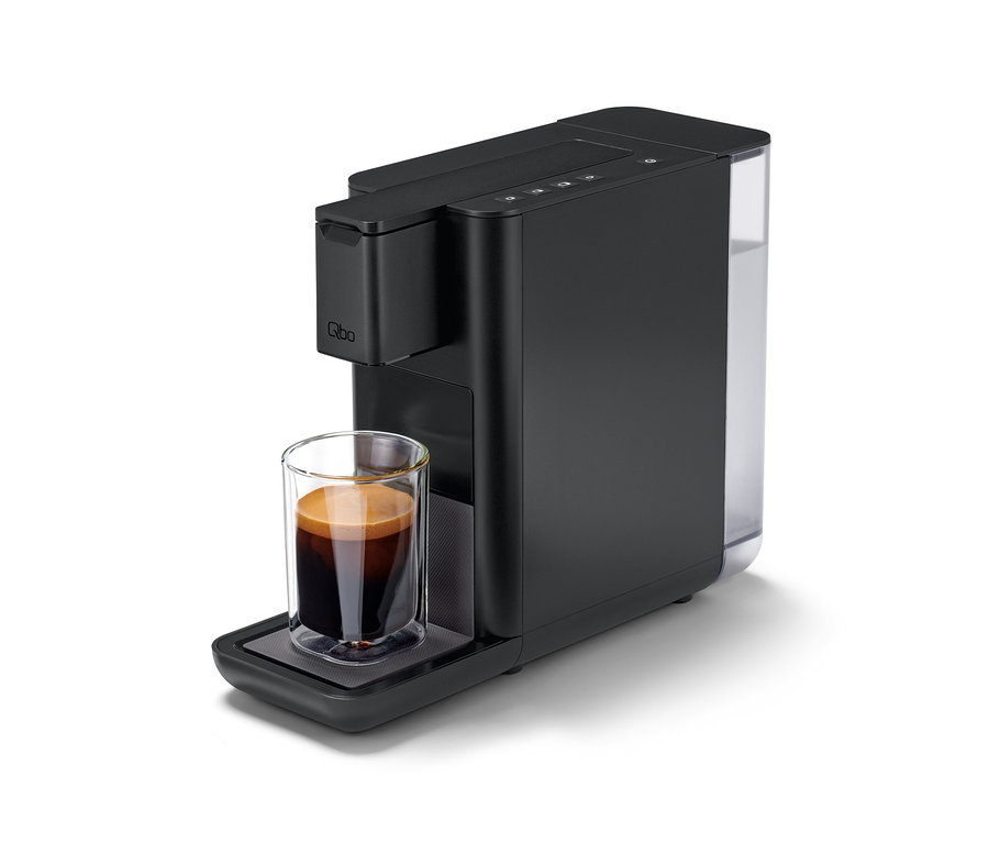 Eine Qbo ICONIC Dark Chrome Kaffeemaschine mit einer Tasse Kaffee.