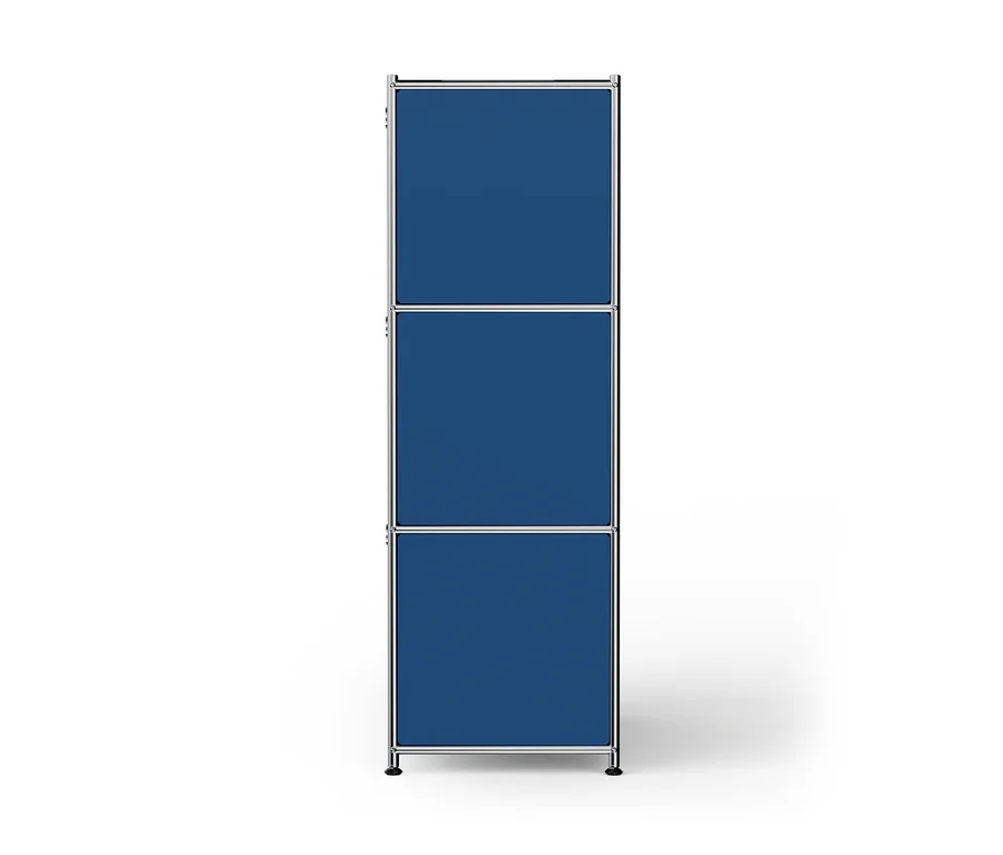 Ein hohes, schmales, modulares Regal mit verchromtem Metallrahmen, drei übereinanderliegenden blauen Fächern und kleinen schwarzen Füßen auf weißem Hintergrund.