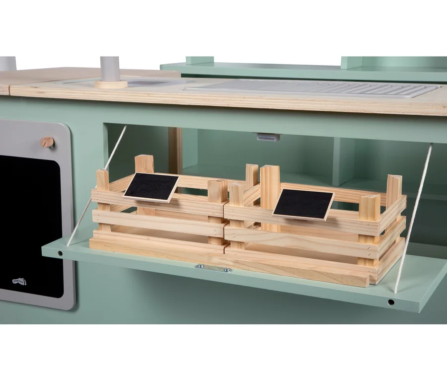 Detailansicht des hellgrünen small foot Kaufladens und Kinderküche »fresh«. Eine herunterklappbare Ablage hält zwei Holzkisten mit kleinen Kreidetafeln. Links ist eine weitere Kreidetafel.