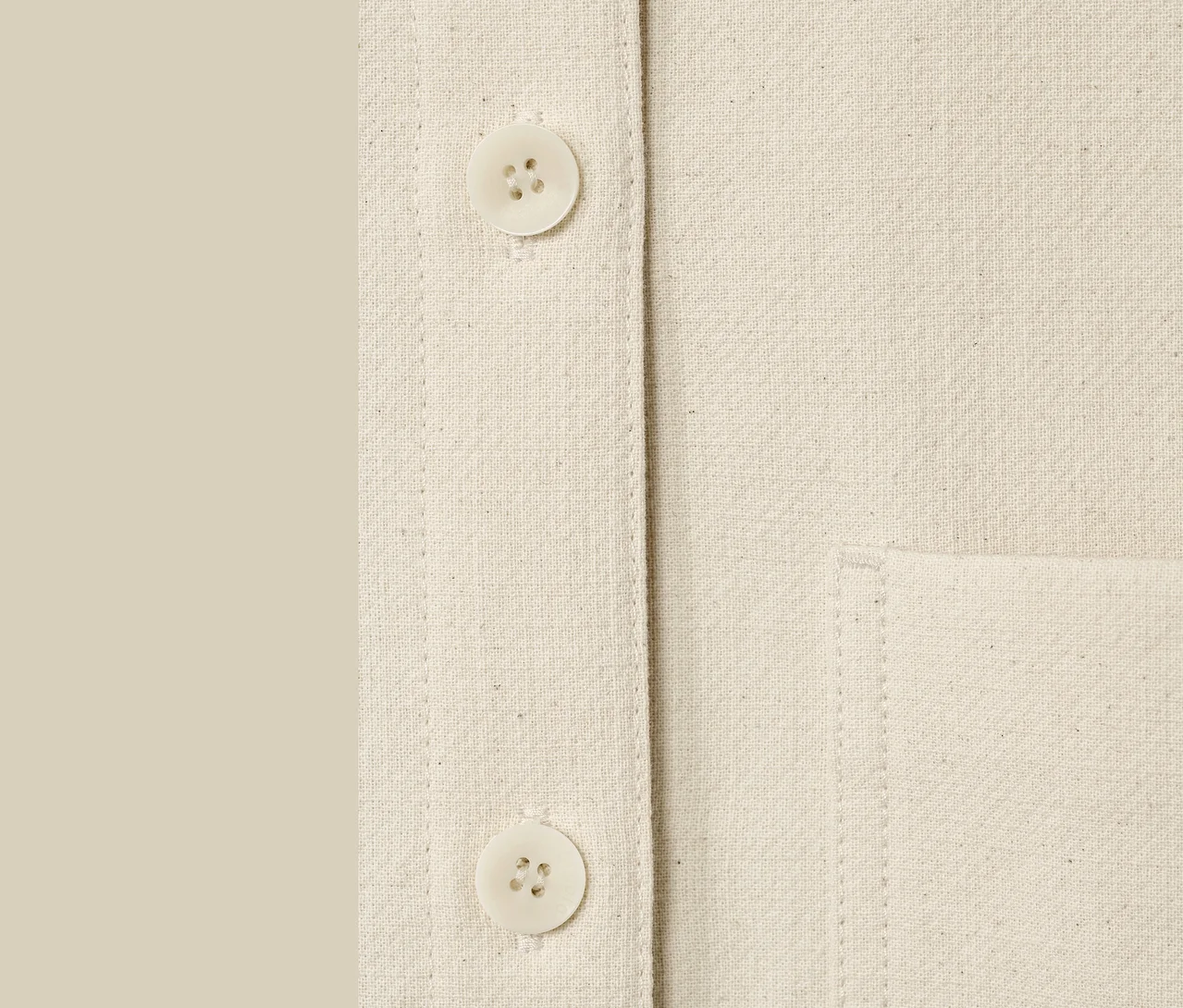 Detailaufnahme einer ungefärbten NAH/STUDIO Blusenjacke mit Knöpfen und Tasche.