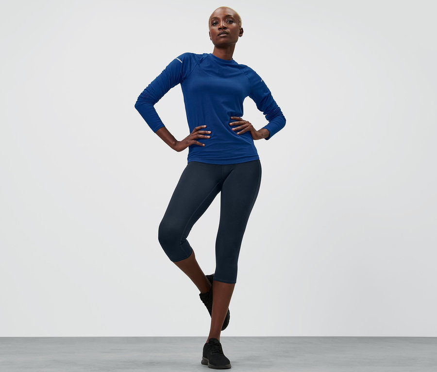 Frau posiert in Sportbekleidung, trägt eine 3/4-Sporttight, navy.