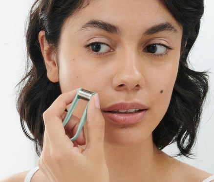 Frau benutzt 2 manuelle Mini-Gesichtshaarentferner im Gesicht.