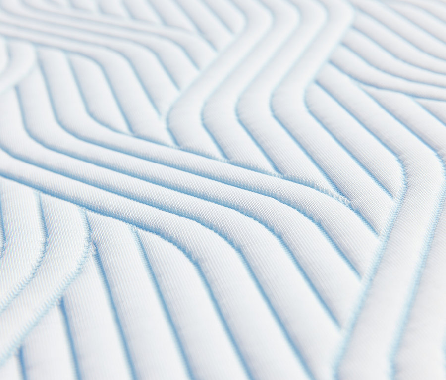 Nahaufnahme der Textur eines TEMPUR Pro® Plus SmartCool™ Topper mit blauen Linien auf weißem Hintergrund.