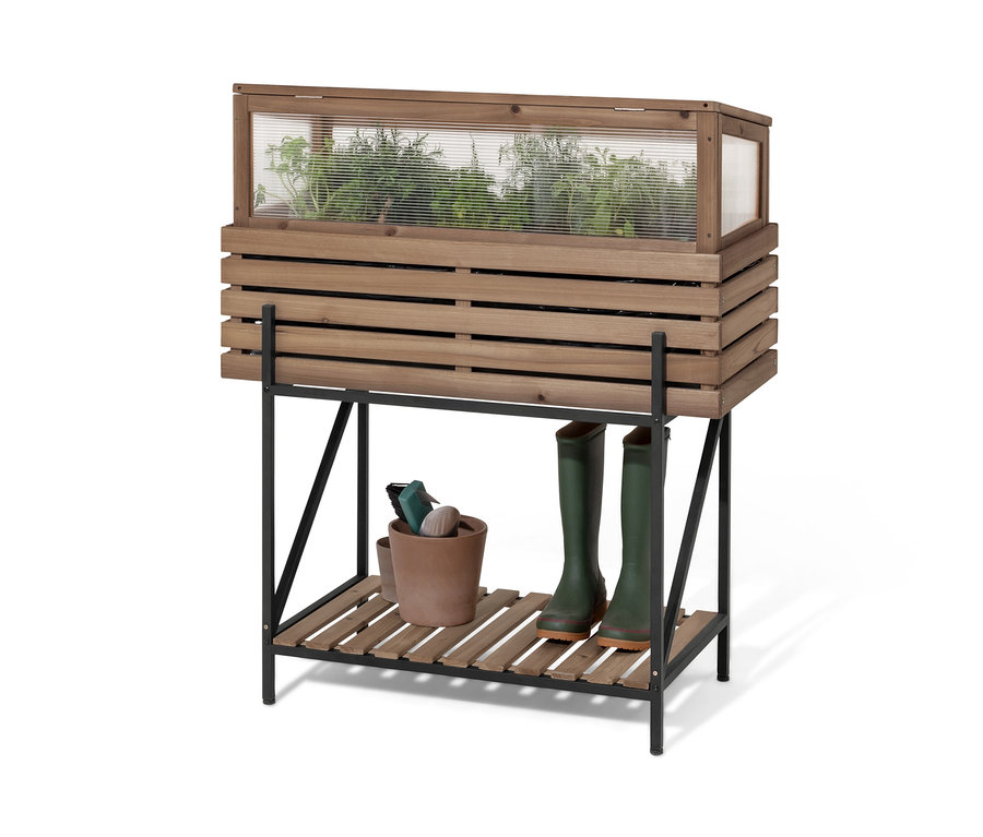 Ein Hochbeet mit Frühbeetaufsatz »Elin« mit Pflanzen, einem Topf und Gummistiefeln.