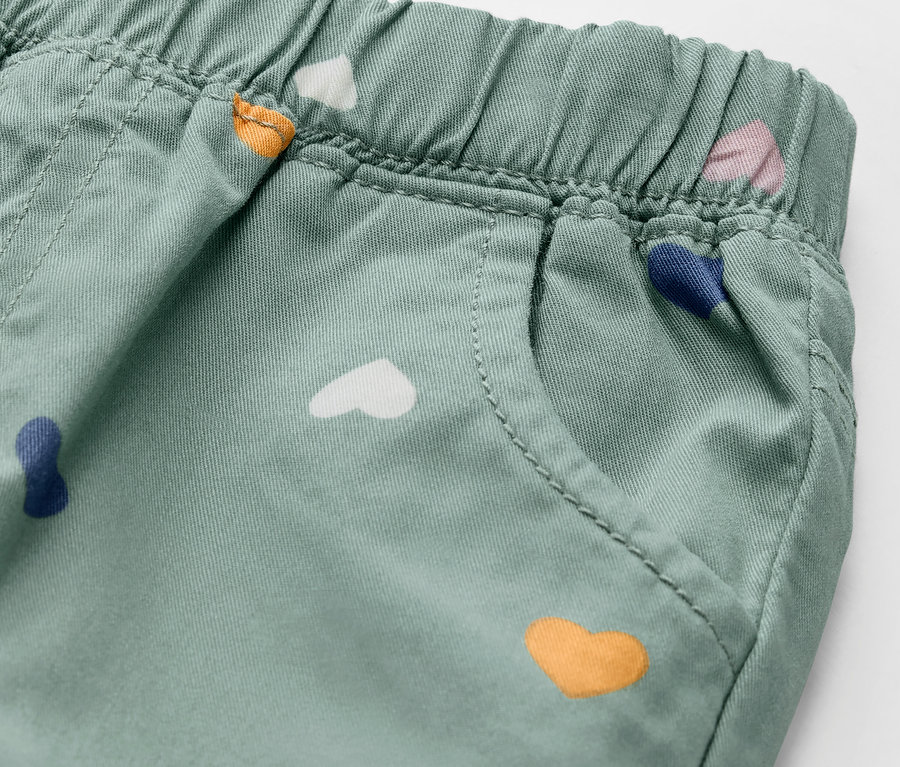 Detail einer Kinder-Pull on pants ‒ Fit »Ella«, pastellgrün, mit bunten Herzen.