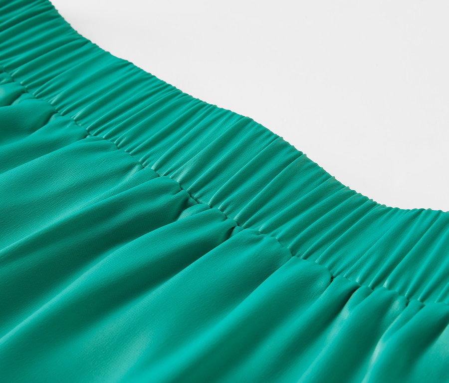 Detailaufnahme eines grünen Satinrocks mit Gummibund.