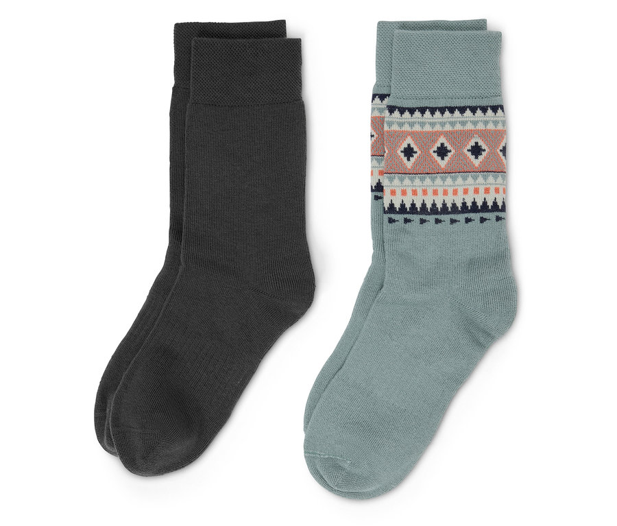 Zwei Paar Socken. Ein Paar ist dunkelgrau, das andere Paar ist hellblau mit einem geometrischen Muster.