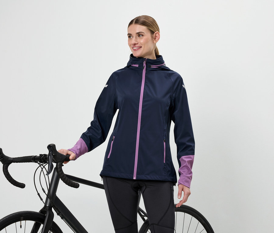 Frau in Jacke hält Fahrradlenker.