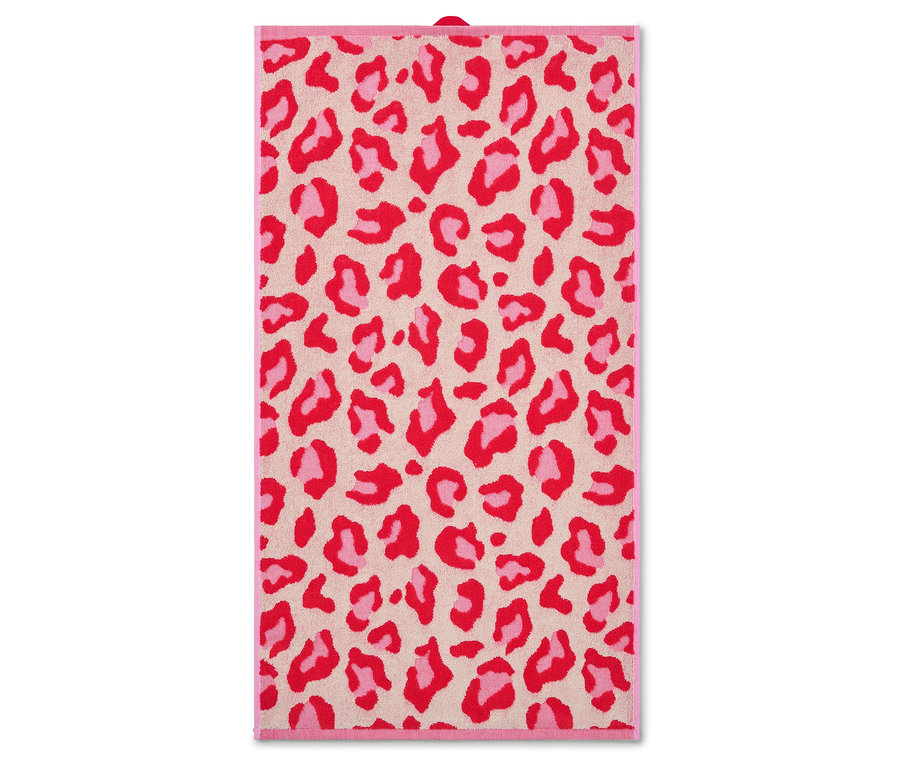 Ein beiges Handtuch mit einem roten und rosa Leopardenmuster hängt.