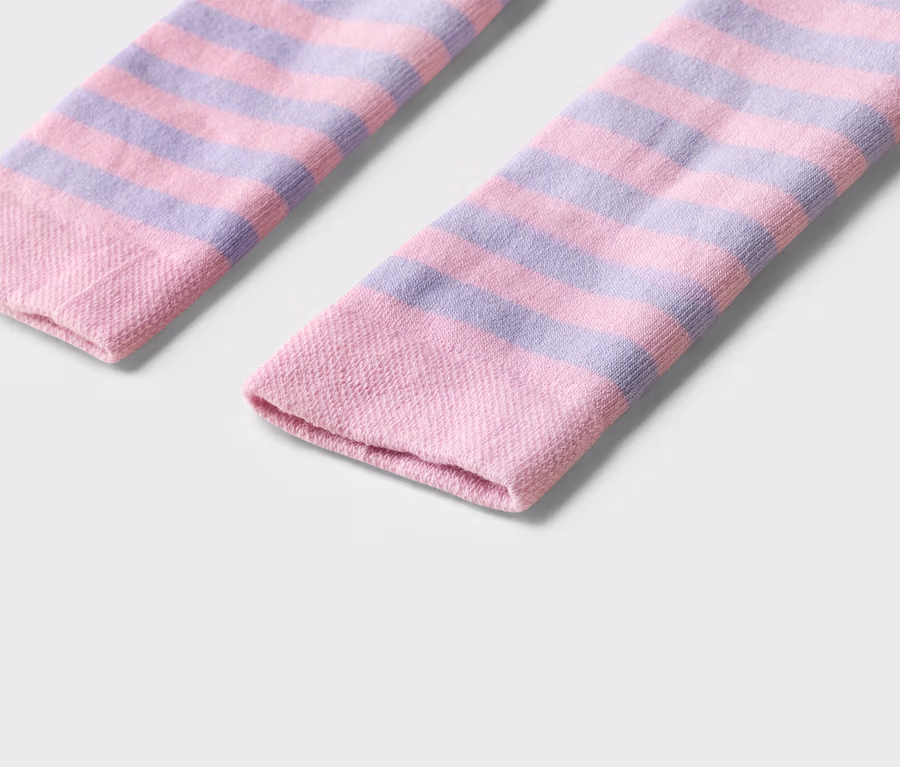 Nahaufnahme von zwei geringelten Socken in Rosa und Lila auf einem weißen Hintergrund.