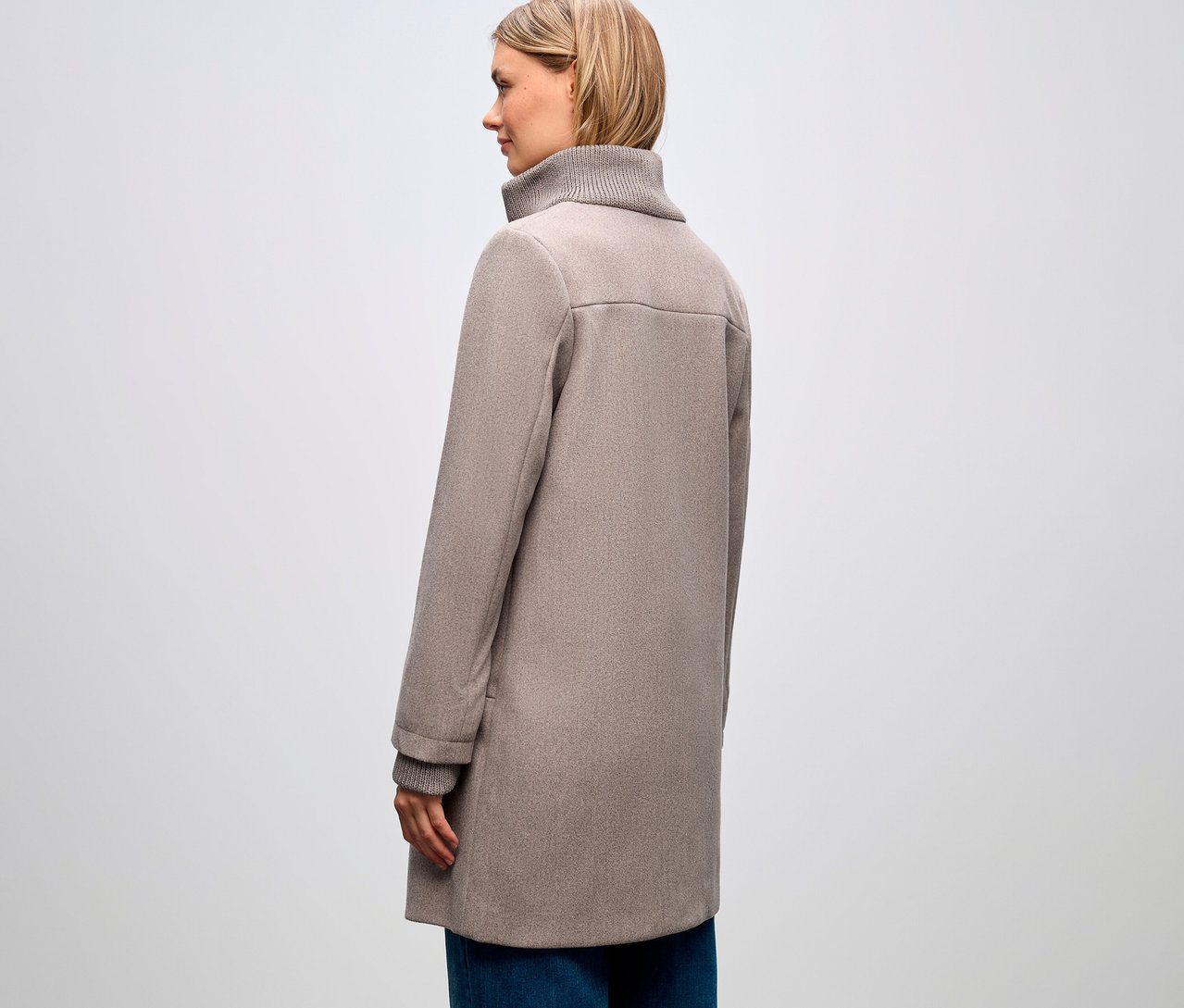 Frau von der Seite, trägt Street One Kurzmantel und blaue Jeans.