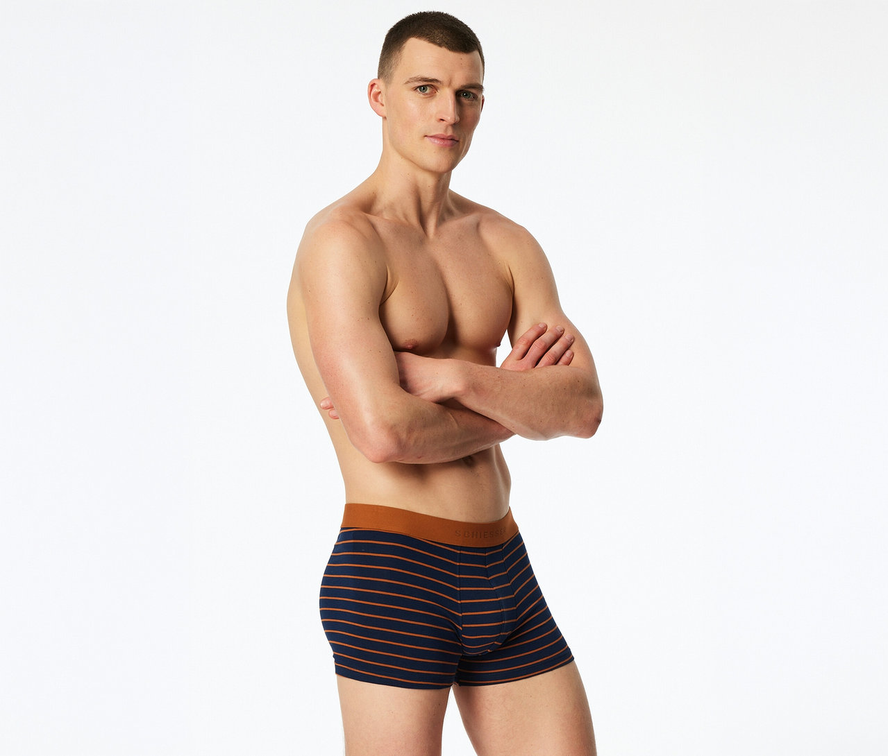 Ein oberkörperfreier Mann mit verschränkten Armen trägt gestreifte SCHIESSER Slipboxer.