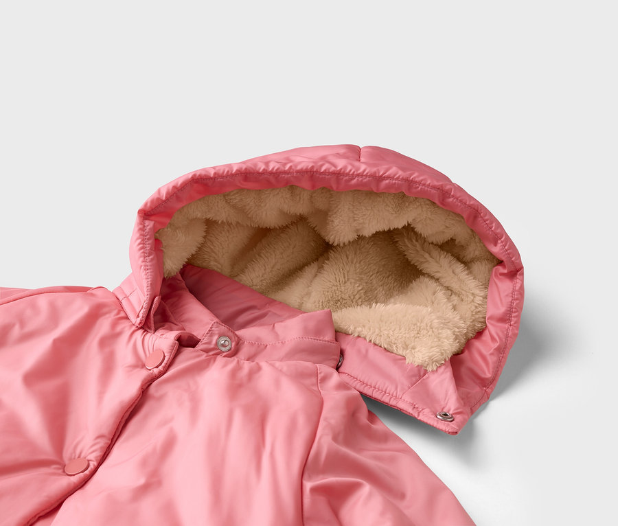 Nahaufnahme einer rosa Jacke mit Kapuze, die mit hellbraunem Kunstfell gefüttert ist. Druckknöpfe sind auf der Vorderseite sichtbar.