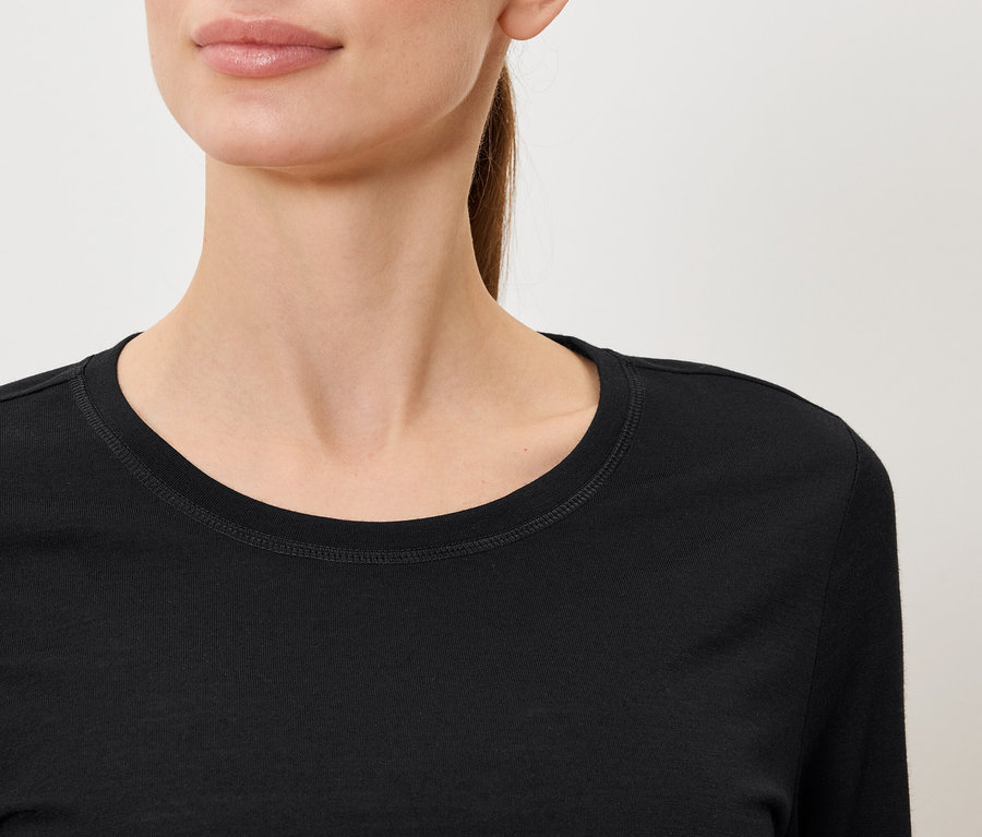 Nahaufnahme einer Frau, die ein schwarzes Langarmshirt trägt.