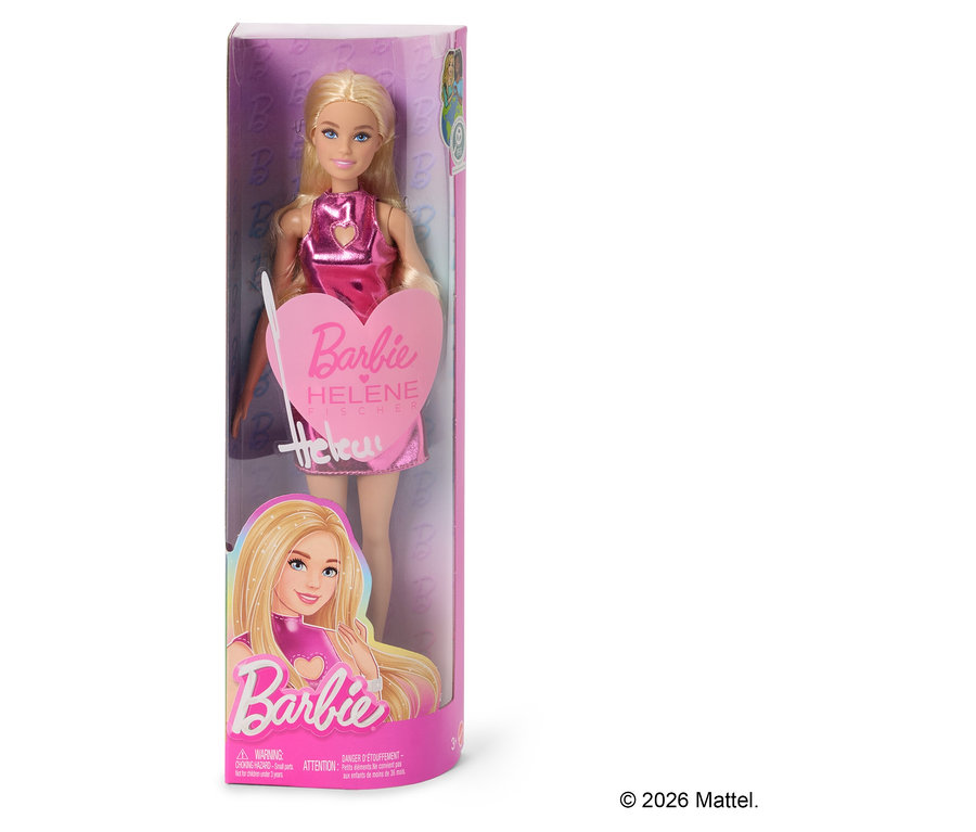Eine Barbie Helene Fischer Puppe in einer durchsichtigen Verpackung. Die Puppe hat blonde Haare und trägt ein glänzendes pinkes Kleid. Auf der Verpackung steht „Barbie Helene Fischer“.