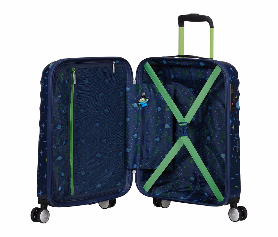 Ein offener, dunkelblauer Koffer mit Weltraummuster aus Sternen und grünen Aliens. Innen links eine Netztasche, rechts grüne Kreuzspanngurte und ein Alien-Schlüsselanhänger.