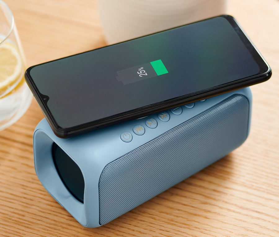 Handy wird auf Lautsprecher mit Qi-Charging geladen.