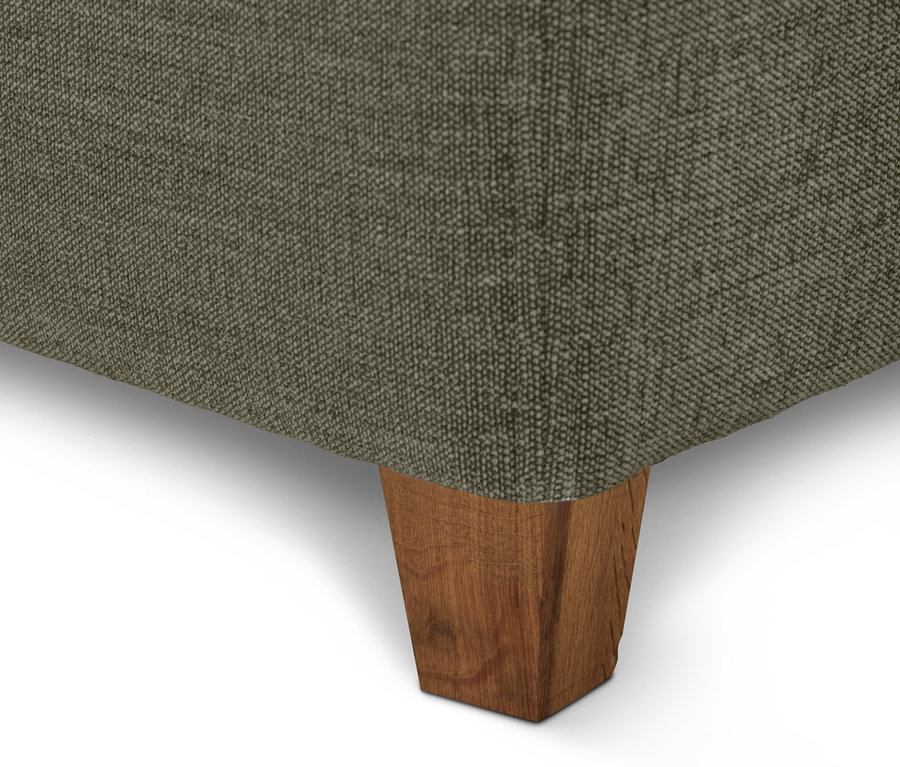 Detailansicht eines hellgrünen Scapa Boxspringbetts mit Holzfüßen.