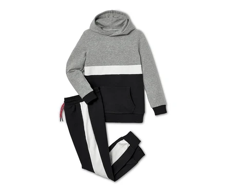 Eine grau, weiss und schwarz farbige Sweat-Kombi, 2-teilig, liegt auf einem weißen Hintergrund.
