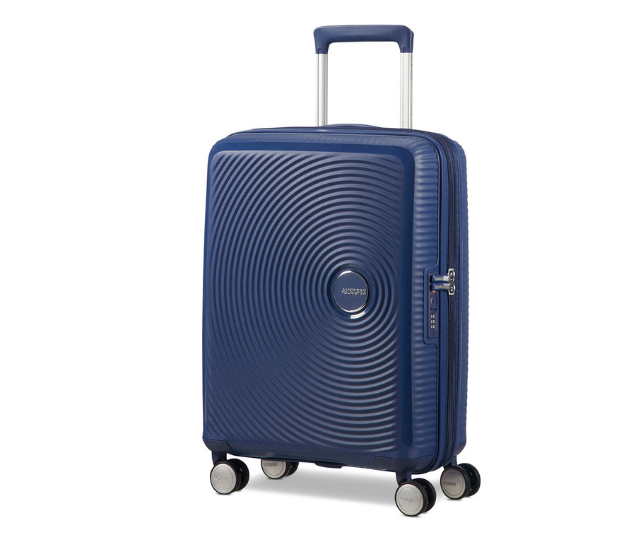 Ein marineblauer American Tourister Hartschalenkoffer »Soundbox« Spinner, klein, mit Teleskopgriff und vier Rollen.