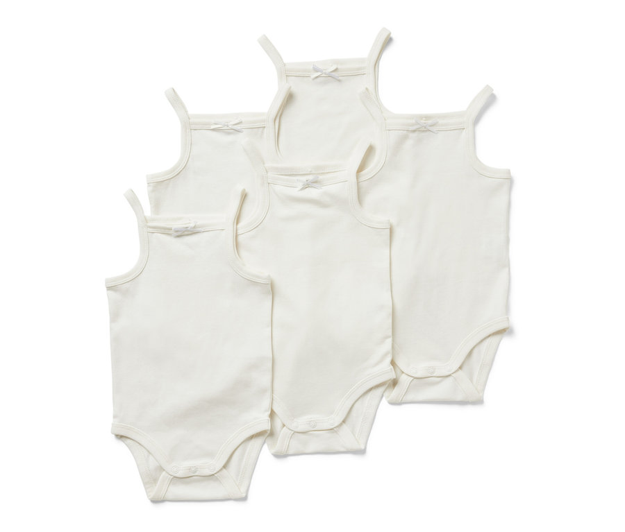 Fünf weiße Baby-Bodys mit Schleifen.