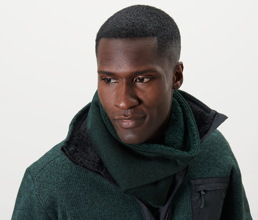 Mann trägt einen grünen Strickfleece-Schlauchschal und eine grüne Jacke.