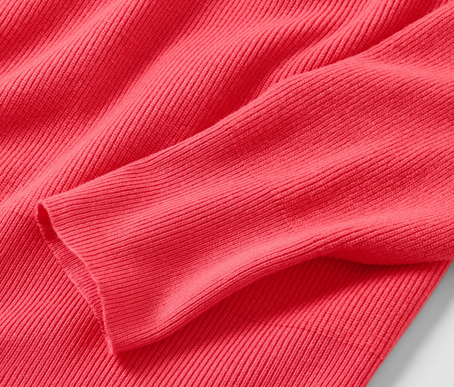 Detailaufnahme eines roten Feinstrickpullovers.