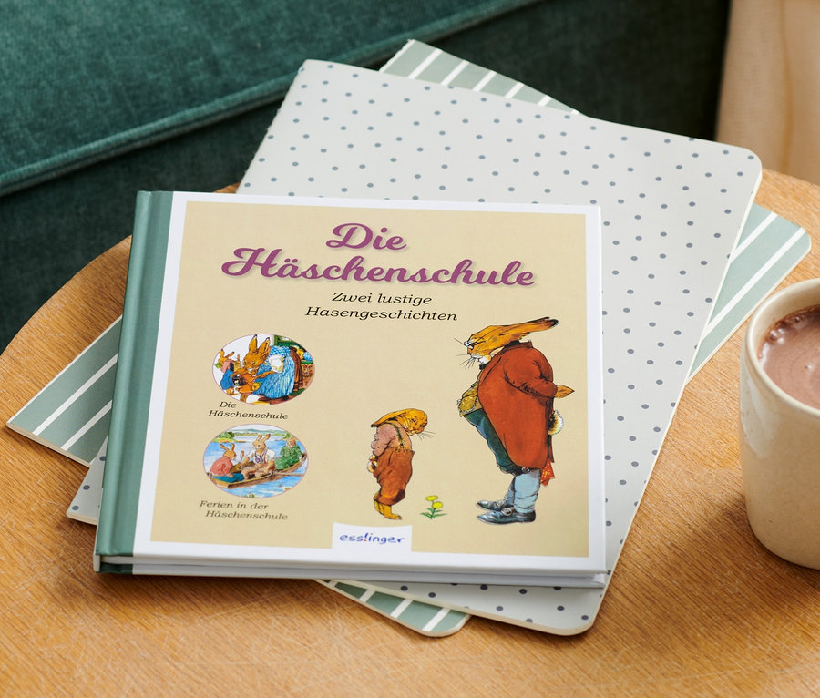 Das Buch »Die Häschenschule« liegt auf einem Tisch neben einer Tasse heißer Schokolade.