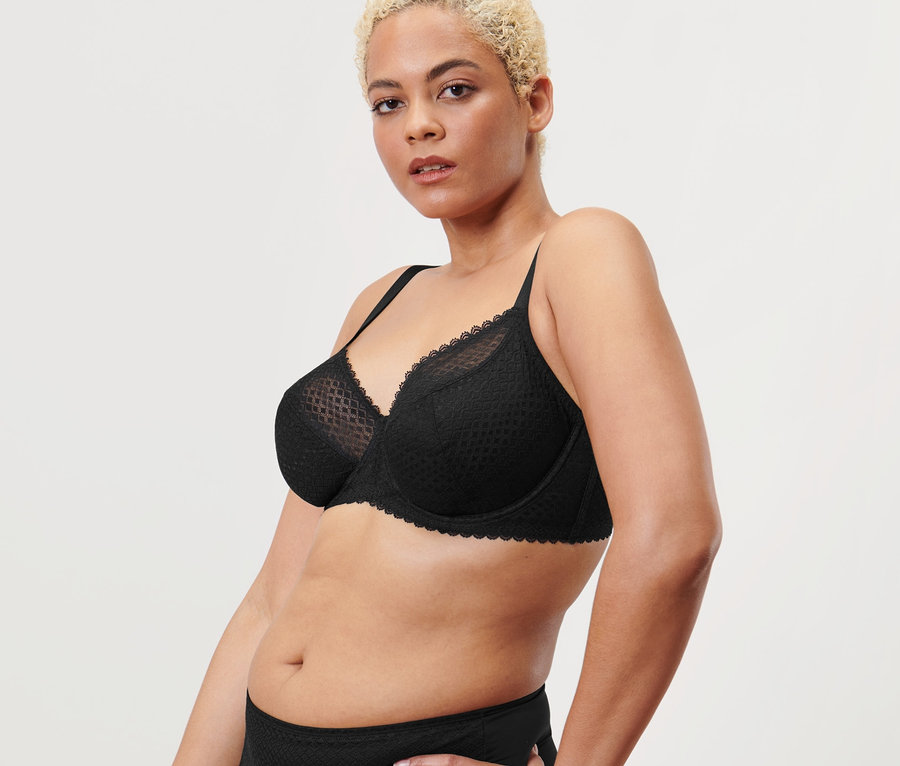 Frau posiert in schwarzem Bügel-BH.