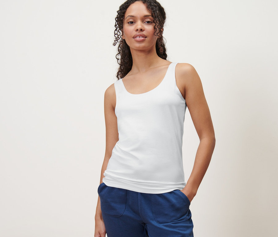 Frau posiert in einem weißen Hemdchen. 2 Hemdchen.