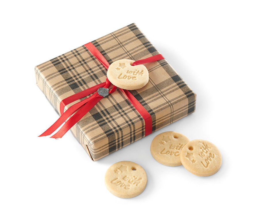 Ein Geschenkpaket mit rotem Band und Keksen mit der Aufschrift "With Love".