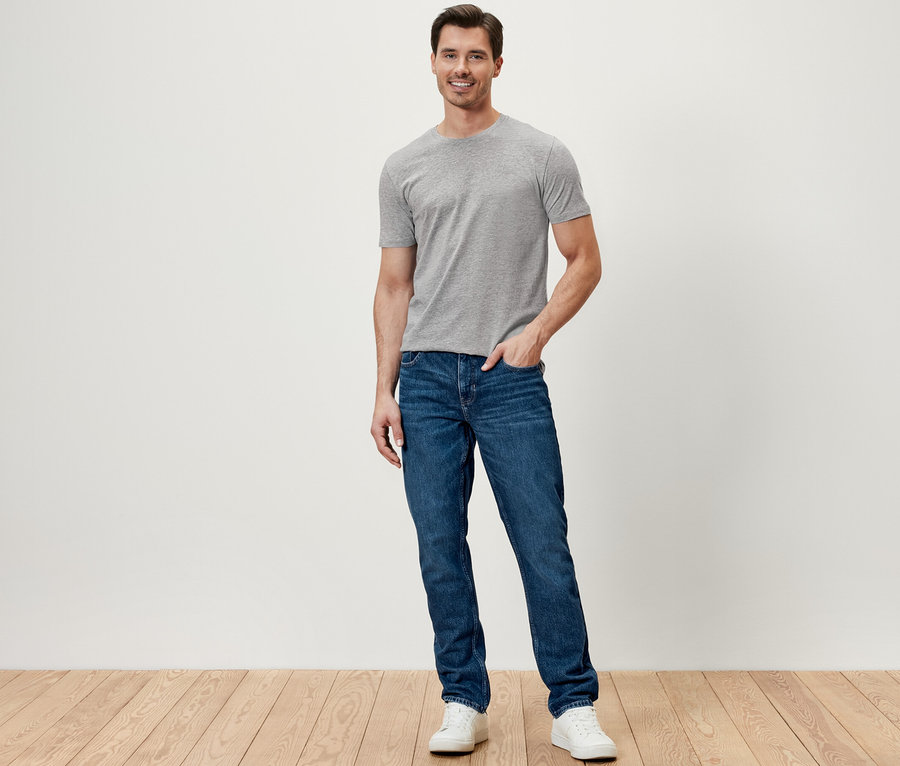 Ein Mann steht und trägt Jeans.