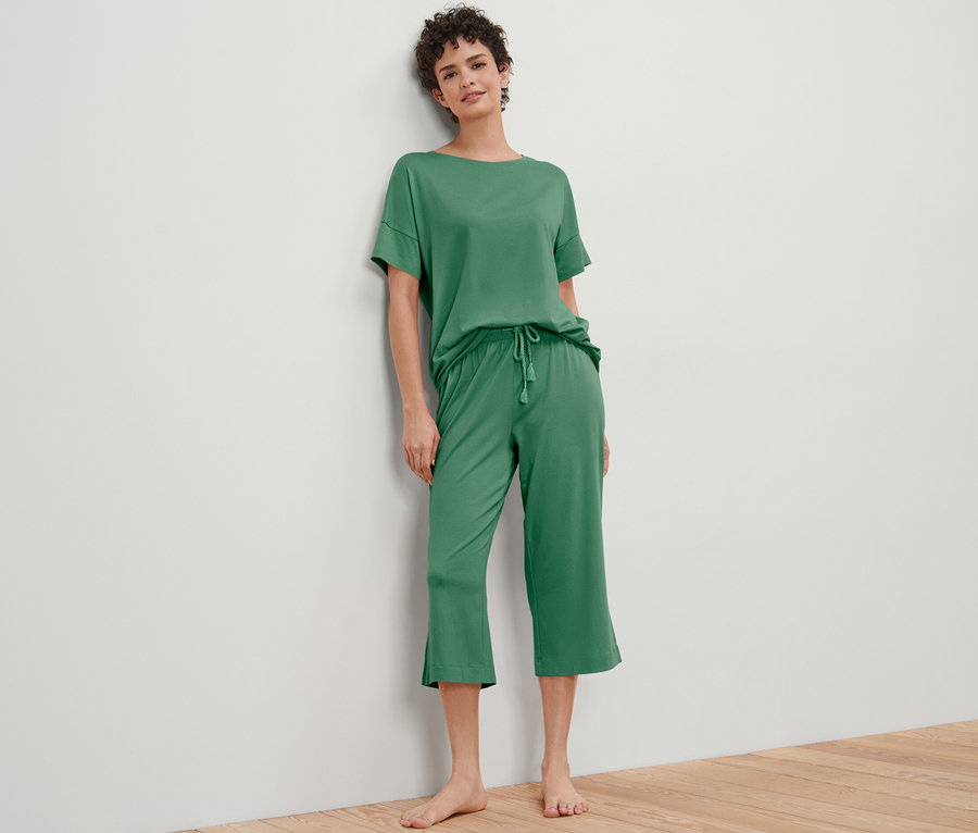 Frau posiert in grünem 3/4-Pyjama-Set.
