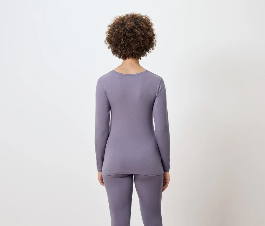 Rückansicht einer Frau mit Afro-Frisur in lila Thermounterwäsche.