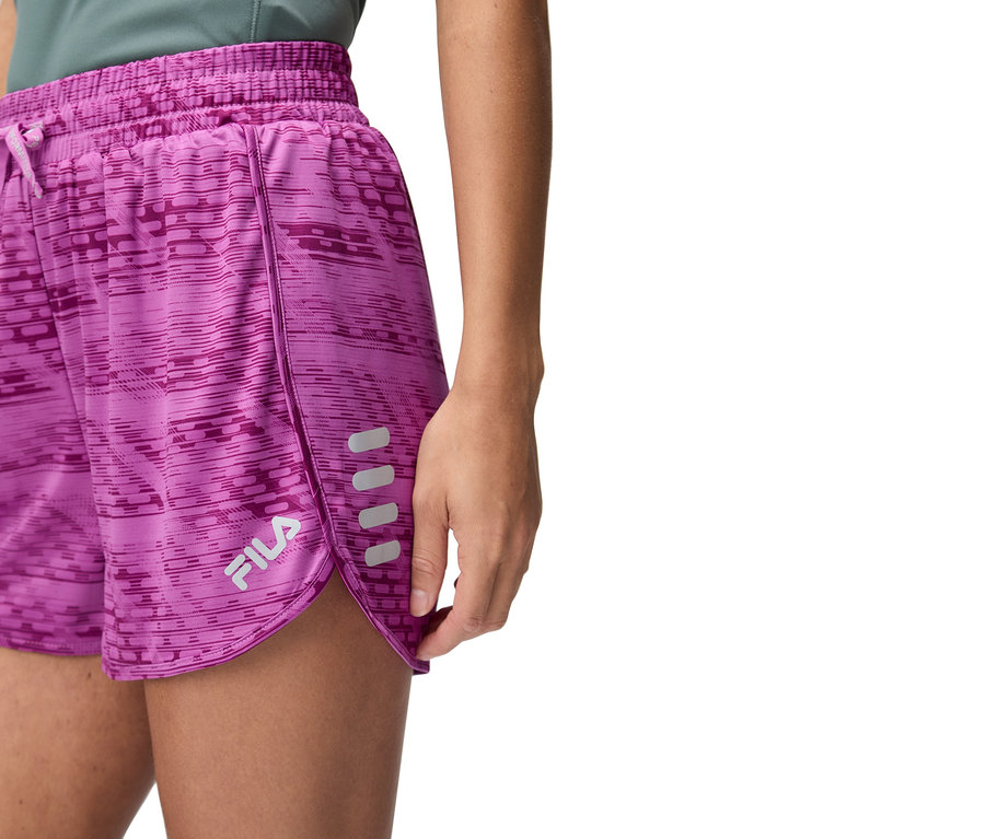 Nahaufnahme einer Frau, die eine lilafarbene Fila-Shorts trägt.