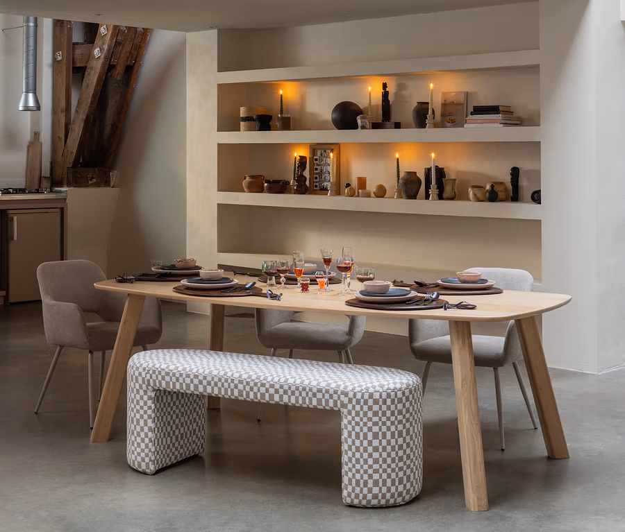 Ein gedeckter WOOOD Tisch »Tablo«, ca. 180 x 100 cm, naturfarben, mit Stühlen und einer karierten Bank in einem Esszimmer. Auf den Regalen brennen Kerzen.
