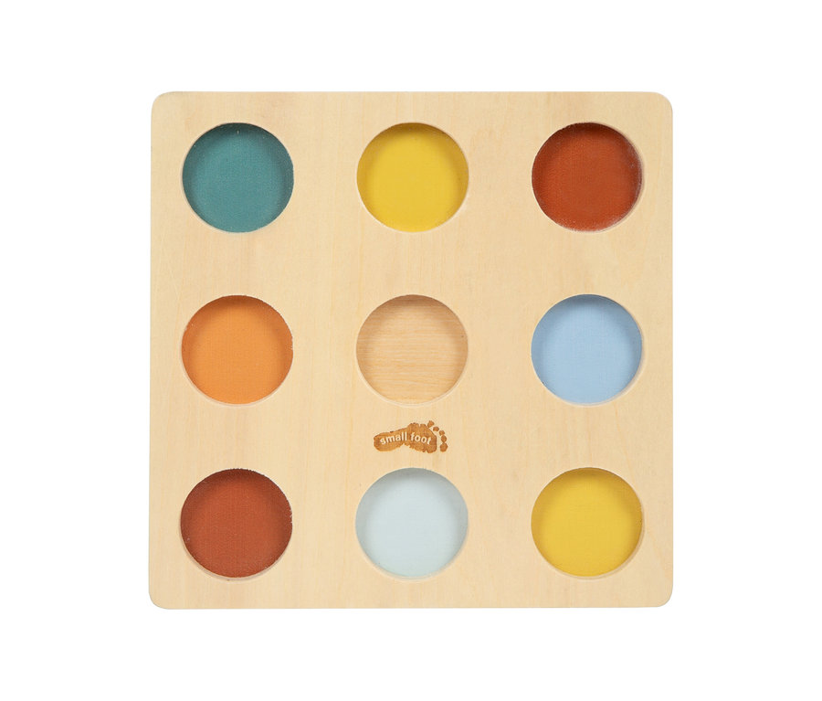 Quadratisches Holzbrett, small foot Montessori-Bundle 2, mit neun runden Vertiefungen. Acht Kreise enthalten verschiedenfarbige Stoffe: Petrol, Gelb, Rotbraun, Orange, Hellblau, Dunkelrotbraun, Hellblau-Grau und Gelb. Der mittlere Kreis ist Naturholz.