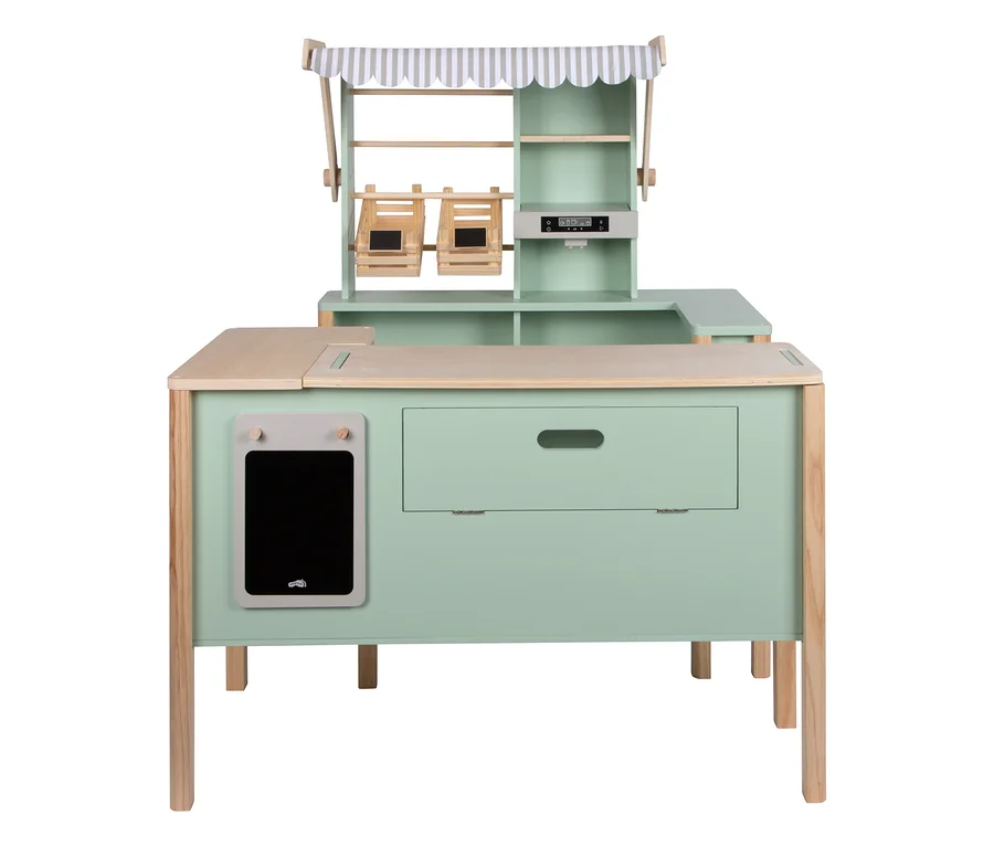 Ein mintgrüner small foot Kaufladen und Kinderküche »fresh« aus Holz mit einer gestreiften Markise, Regalen, zwei Holzkisten, einer Waage, einer Theke, einer Schublade und einer Tafel.