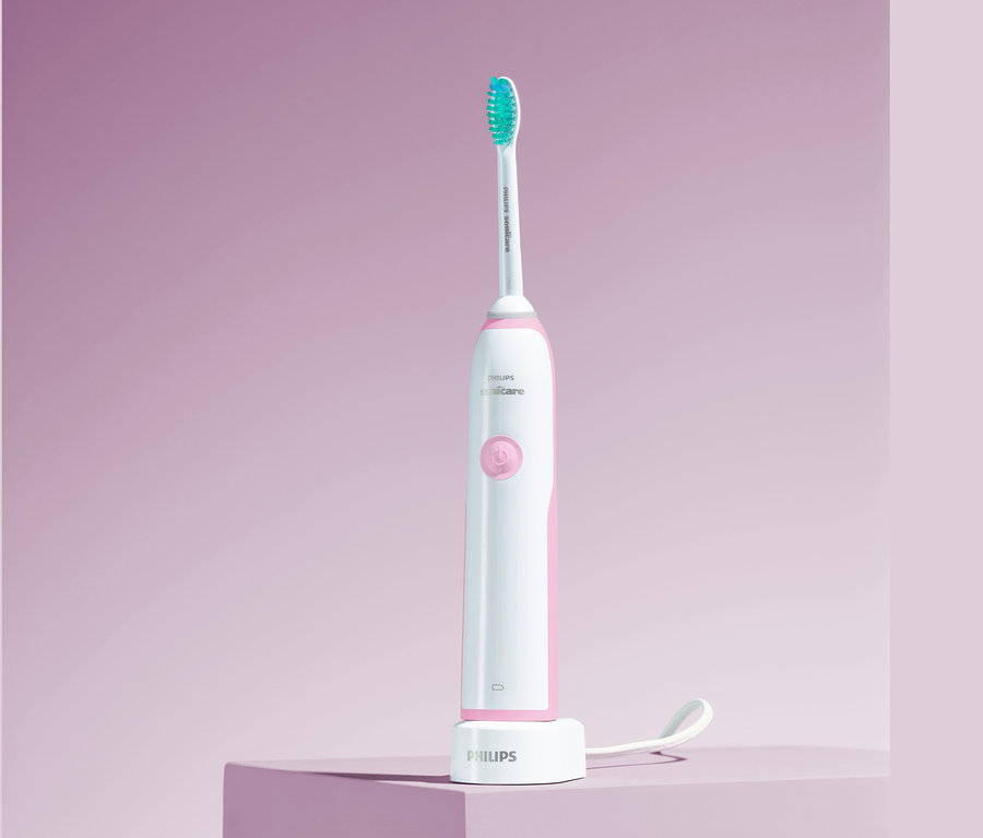Elektrische Schallzahnbürste Philips Sonicare CleanCare+ HX3212/43 auf lila Hintergrund.