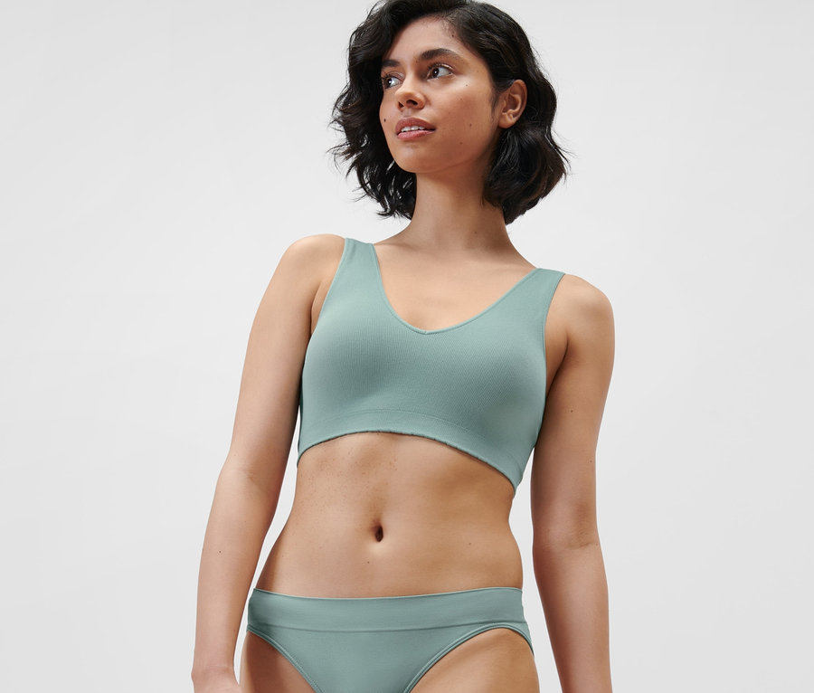 Frau trägt ein Seamless-Bustier in Aqua und passende Unterwäsche.