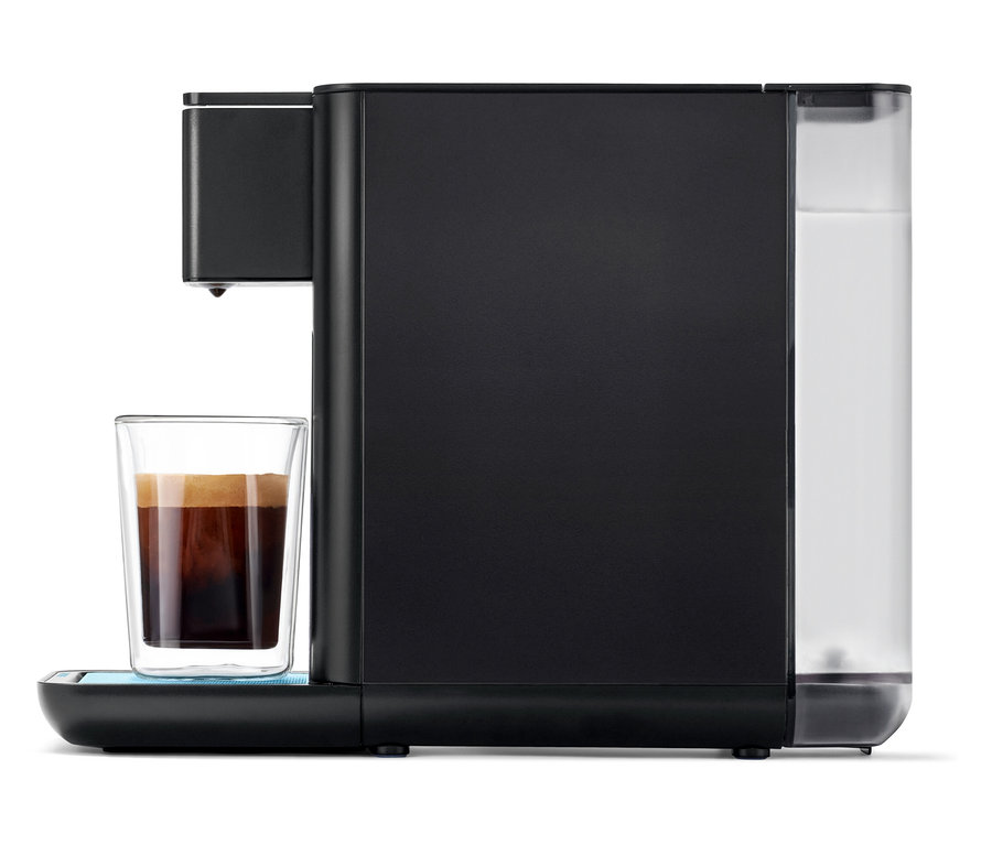Qbo ICONIC x Pantone Special Edition Sky Blue Kaffeemaschine füllt ein Glas mit Kaffee.