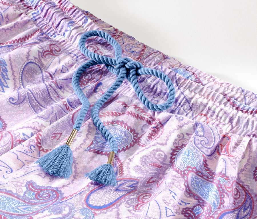 Detailansicht eines Shorty-Pyjama-Sets mit lila Paisleymuster und blauem Kordelzug.