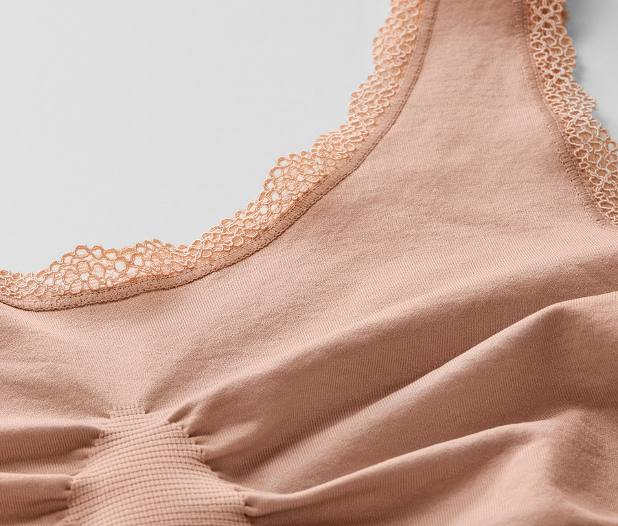 Detailansicht eines beigen Seamless-Bustiers mit Spitze.