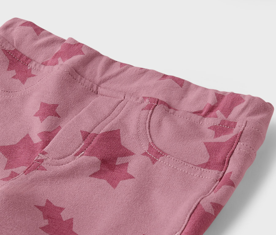 Detail einer rosafarbenen Hose mit Sternen und einer Tasche.