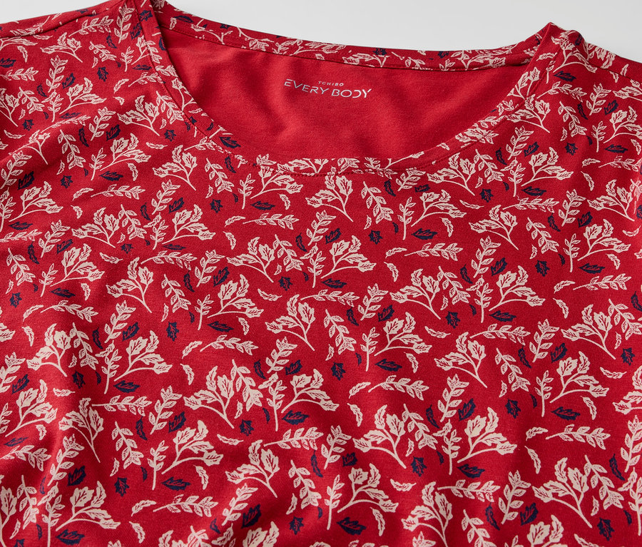 Detailansicht eines roten T-Shirts mit Blattmuster.