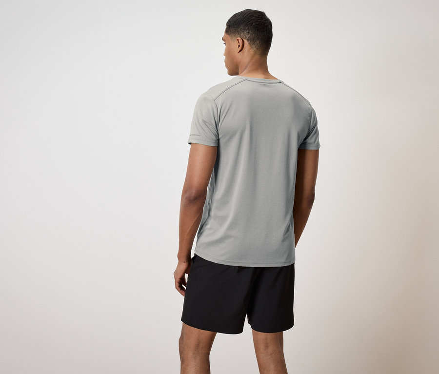 Mann von hinten trägt ein graues T-Shirt und schwarze Shorts.